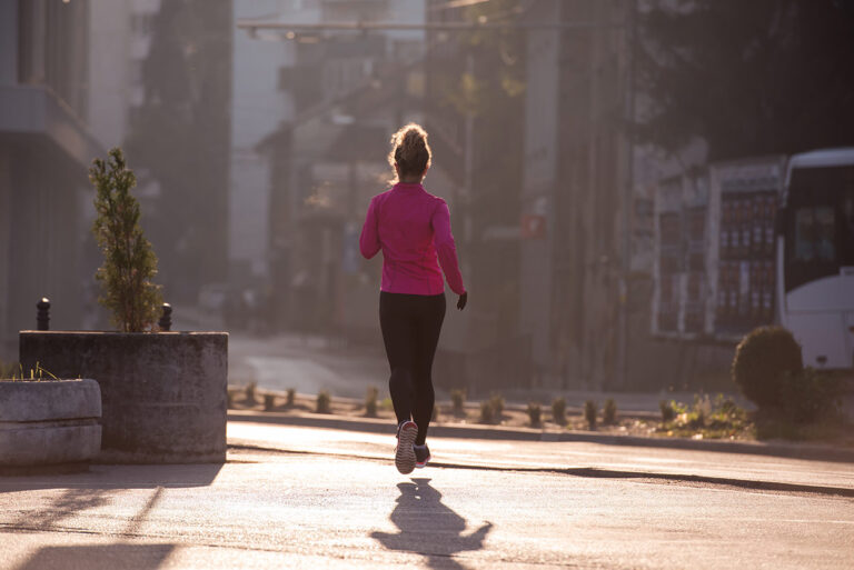 Cómo preparar un 10K desde cero: mujer corriendo sola por ciuidad